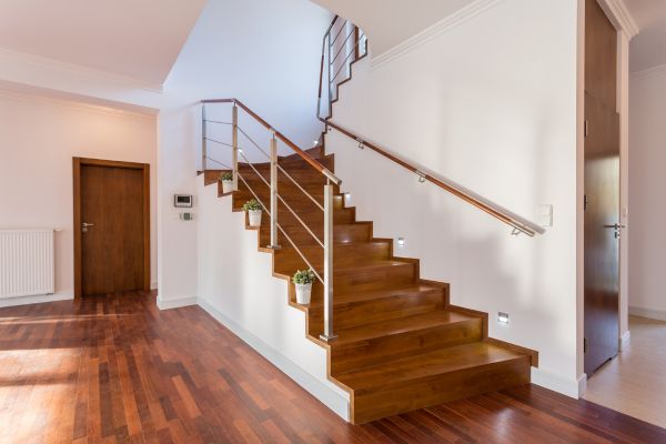 An elegant staircase with a dark wood skirt board contrasting with light-colored walls.