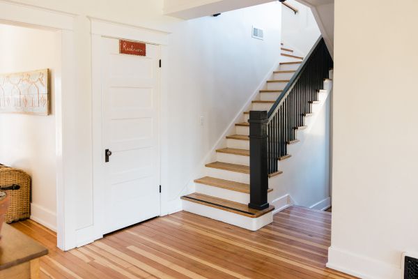 A close-up view of a white stair skirt board meeting the wooden stair treads.