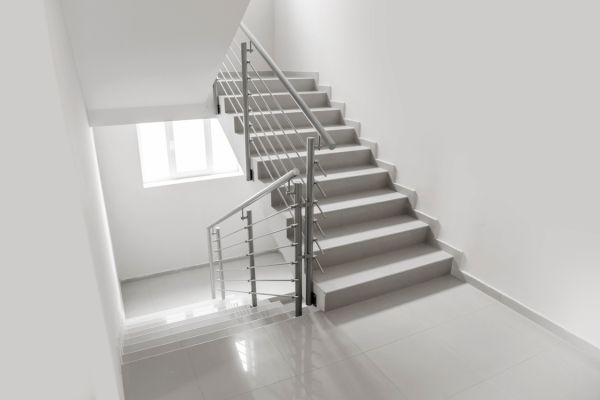 A freshly painted white skirt board on a modern staircase.