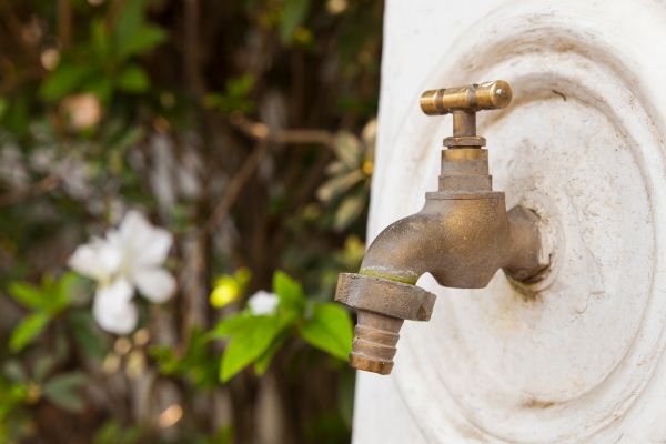 un robinet en laiton avec des gouttes d'eau dessus