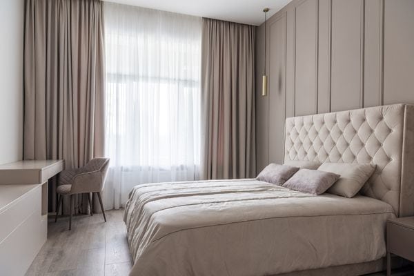 A discreet ceiling-mounted curtain track with ripplefold curtains