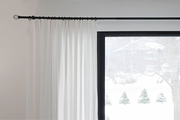 A decorative curtain rod with ornate finials